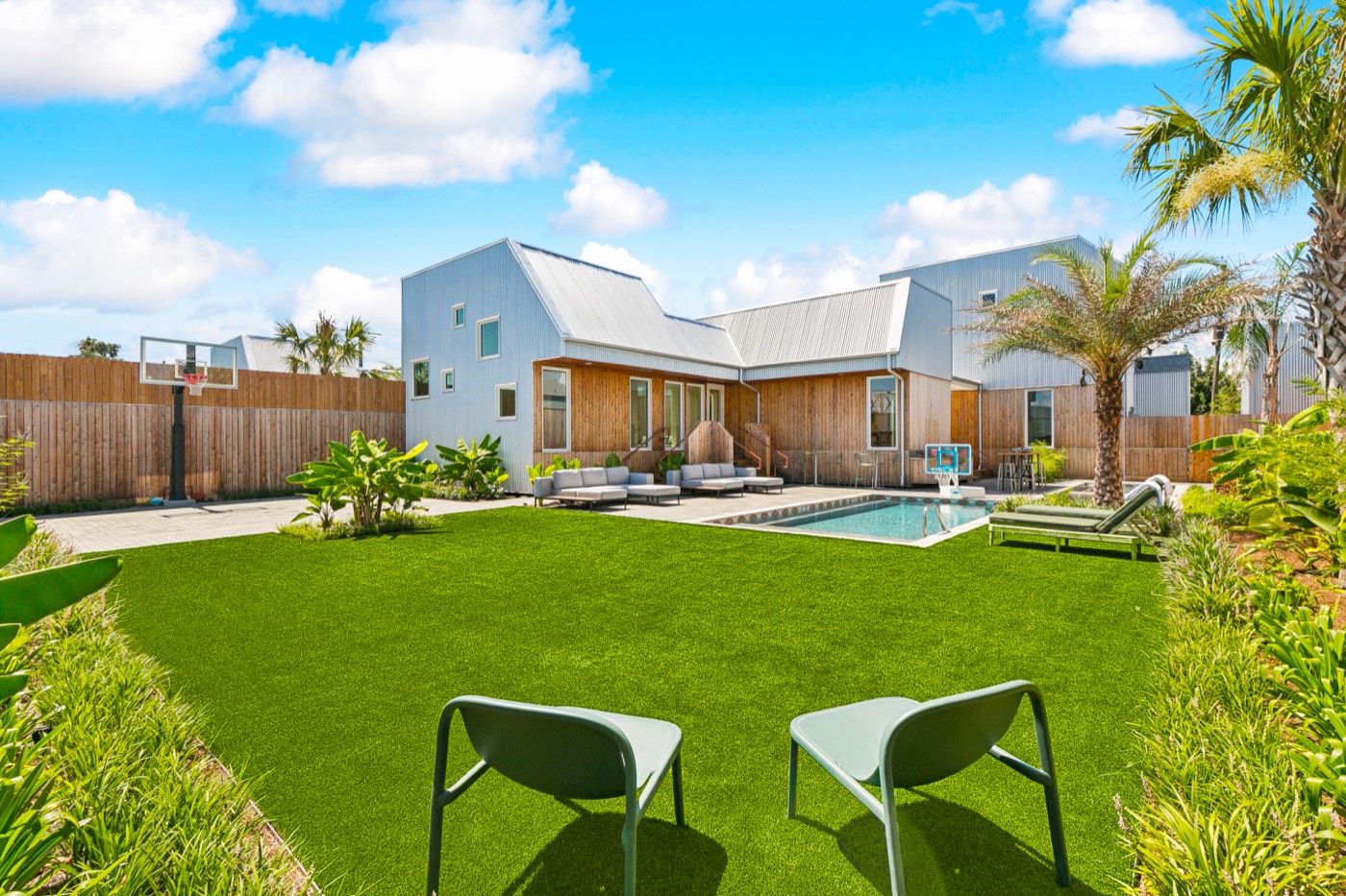 Big lawn with cornhole, villa and pool behind at Castleday Retreats